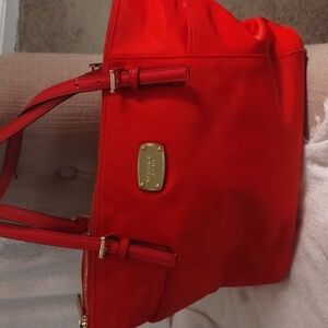 Maroon/red Michael Kors tote. Tote has been used. Call out on strap and marks